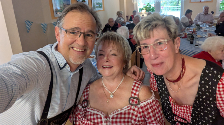 drei Menschen mit Oktoberfestkleidung lachen in die Kamera